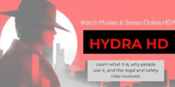 Silhouetted person in a trench coat and wide-brim hat facing left against a red and white cityscape background. The text reads “HYDRA HD” with a tagline about watching movies and series online. A box below explains that the platform has legal and safety risks.