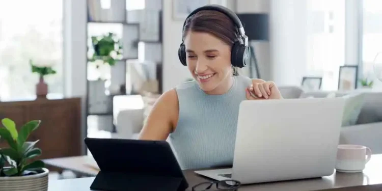 Remote virtual assistant working from home office with laptop, planner and coffee, planning 90 day roadmap to start online business