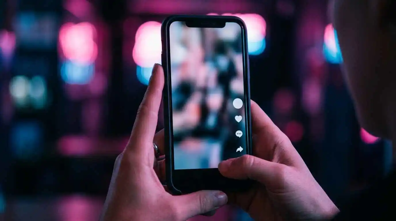 Smartphone screen showing a vertical video feed with engagement icons, symbolizing TikTok algorithm mechanics